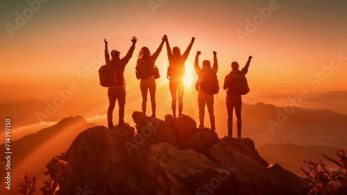 Silhouette of a group of climbers celebrating their accomplishment on the top of the mountain with a rising sun and sunlight Generative AI
