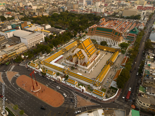 An aerial view of Red Giant Swing and Suthat Thepwararam Temple at sunset scene, The most famous tourist attraction in Bangkok, Thailand.