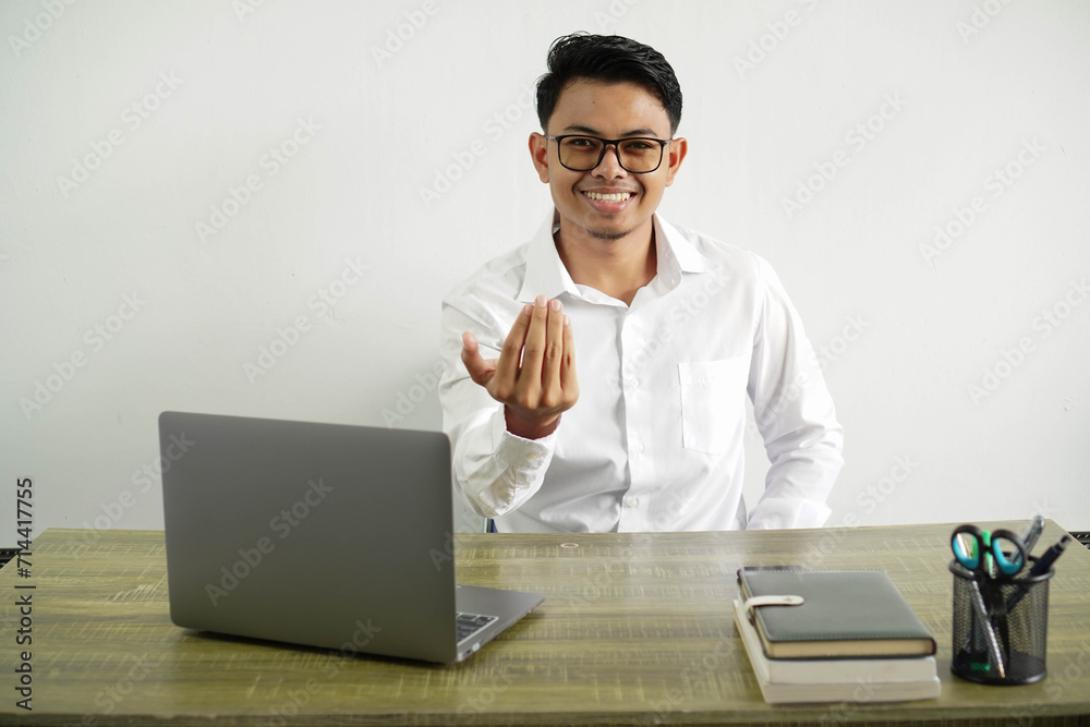 young asian businessman in a workplace inviting to come with hand. happy that you came, wear white shirt with glasses isolated young asian businessman in a workplace inviting to come with hand. happy that you came, wear white shirt with glasses isolated