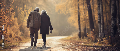 Elderly Couple's Peaceful Autumn Walk: A Heartwarming Scene of Togetherness Amidst Golden Fall Foliage photo