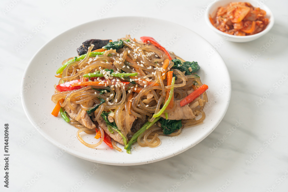 japchae or stir-fried Korean vermicelli noodles with vegetables and pork topped with white sesame