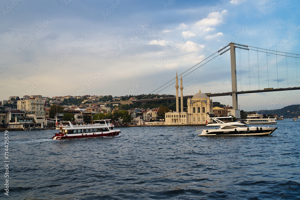 Historic Grand Mecidiye mosque under the famous bosporus bridge linking europe to asia during bosporus boat tour and cruise, Istanbul, Turkey