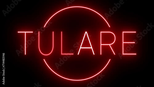 Flickering red retro style neon sign glowing against a black background for TULARE photo