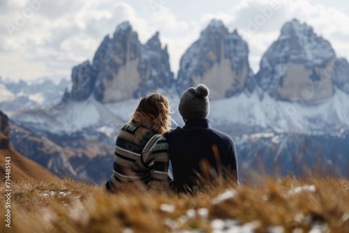 A couple on a romantic getaway in the Italian Dolomites, sitting together on a hill and enjoying each other’s company