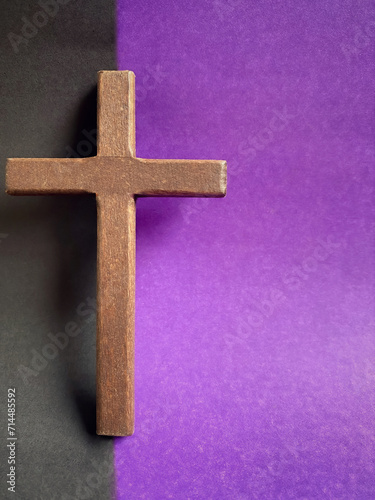 Lent Season, Holy Week, Good Friday, Easter Sunday Concept. Close up of wooden cross with black and purple colours background. For copy space.