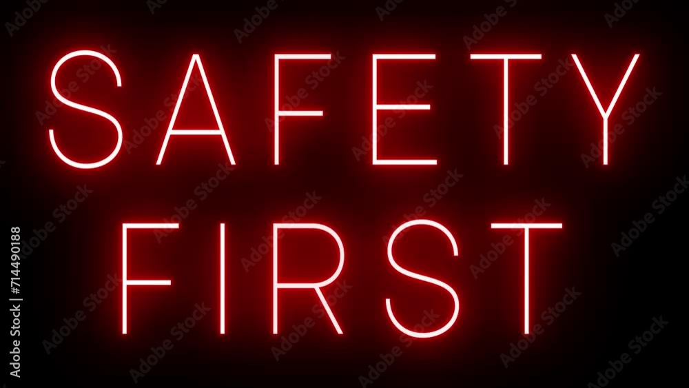 Flickering red retro style neon sign glowing against a black background for SAFETY FIRST Flickering red retro style neon sign glowing against a black background for SAFETY FIRST