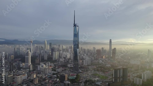 Establishing aerial cinematic b-roll shot of sunrise at Kuala Lumpur city skyline with highest building in Asia. 