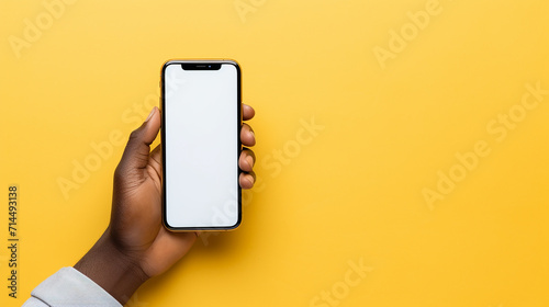 african-american person holding phone on yellow background