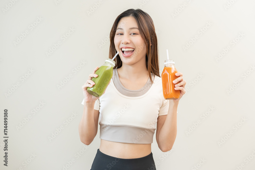 Orange, green detox juice, smile asian young woman hand holding bottle of vegetable juice, carrot smoothie for diet, girl drinking healthy meal food for weight loss, standing isolated on background Orange, green detox juice, smile asian young woman hand holding bottle of vegetable juice, carrot smoothie for diet, girl drinking healthy meal food for weight loss, standing isolated on background