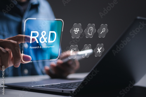 R and D, Research and Development concept. businessman use laptop with virtual R and D icons for research and development of business science technology. photo
