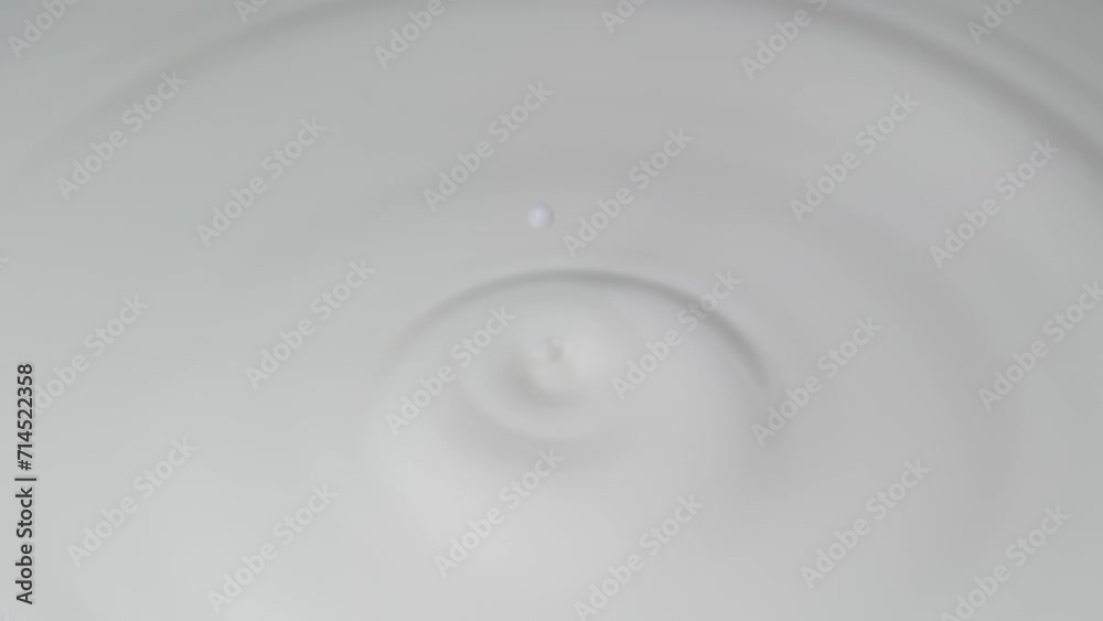 Drop of milk falling into a full glass,4K,slow motion Drop of milk falling into a full glass,4K,slow motion