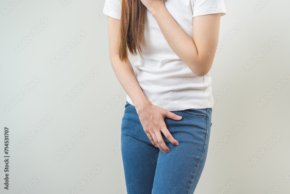 Vaginal, urinary incontinence. Pain asian young woman hand holding