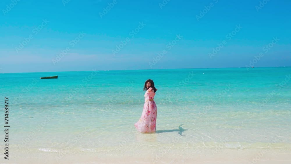 Indian girl with raised hands enjoying summer vacation at tropical beach in Lakshadweep Island, India. Female tourist at white sand beach. Indian girl with raised hands enjoying summer vacation at tropical beach in Lakshadweep Island, India. Female tourist at white sand beach.