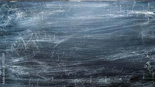 A used black chalkboard fills the image, showcasing the remnants of white chalk marks after erasure, giving it a textured appearance that's both dynamic and familiar.