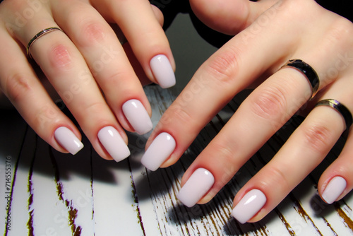 gentle manicure. fashionable light manicure on female hands with rings on fingers  beauty concept