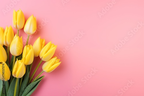 tulips frame, yellow bouquet of tulips on a light pink background—flat lay, with copy space.