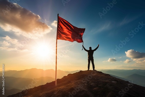 Silhouette of businessman holding flag on the top of mountain with over blue sky and sunlight. It is symbol of leadership successful achievement with goal and objective target photo