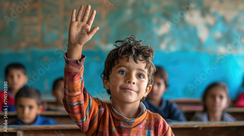 A child raises his hand in class.