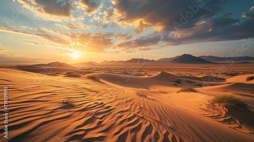  the sun sets over a desert landscape with sand dunes and mountains in the distance in the distance is a mountain range in the distance  and a few clouds in the sky.