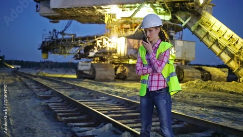 Female worker is talking on walky-talky near career stacker. photo
