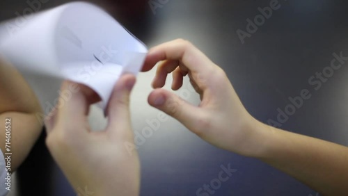 Hands of the girl folds a sheet of paper in the Mobius strip