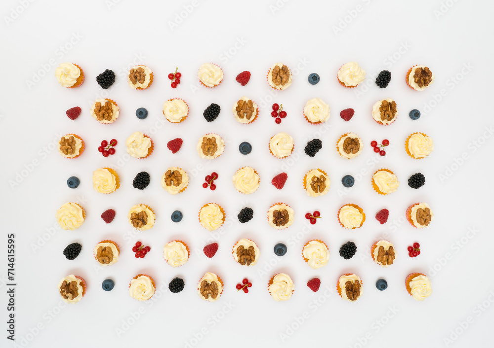 cupcakes and berries laid out on a white background cupcakes and berries laid out on a white background
