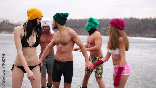 Three man and two women in underwear on ice rink at winter photo