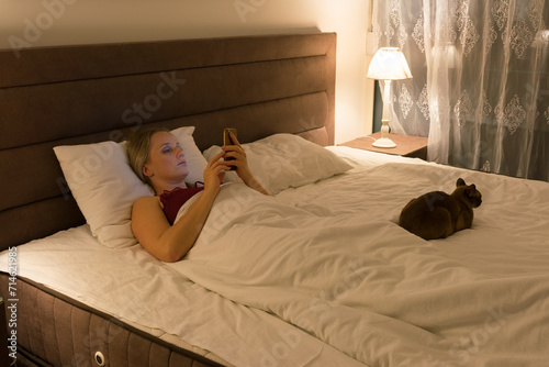 woman in bed before going to sleep with phone in hand