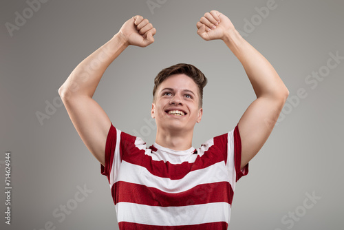 Obraz na plátně Exuberant success, raised fists, vibrant striped fashion