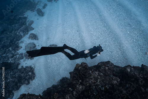 Shallow waterman doing scuba diving in deep blue sea. photo