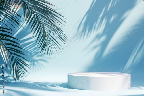 Abstract blue background with white podiums and tropical palm leaves with shadows