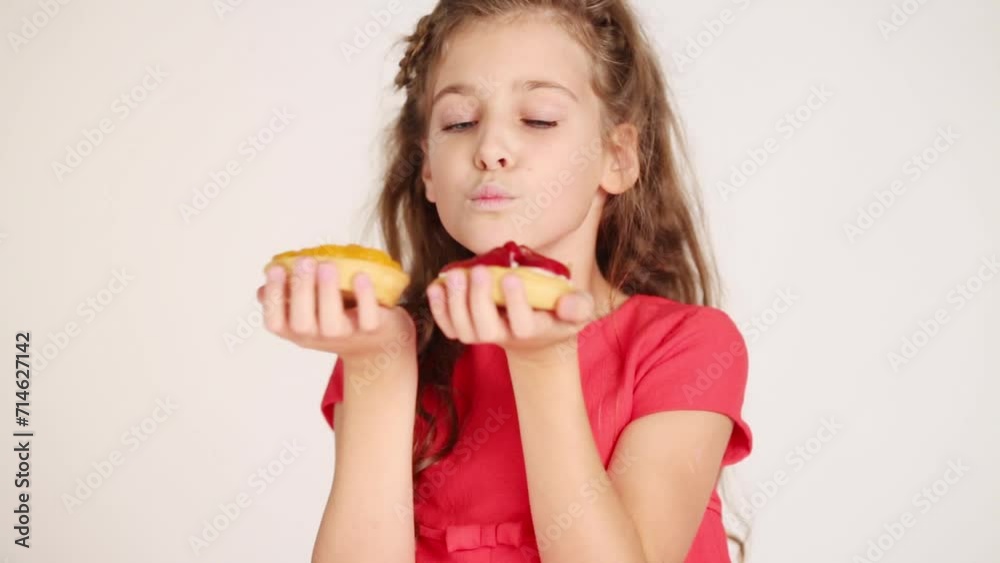 Pretty girl holds two small pies, sniffs it in white studio Pretty girl holds two small pies, sniffs it in white studio
