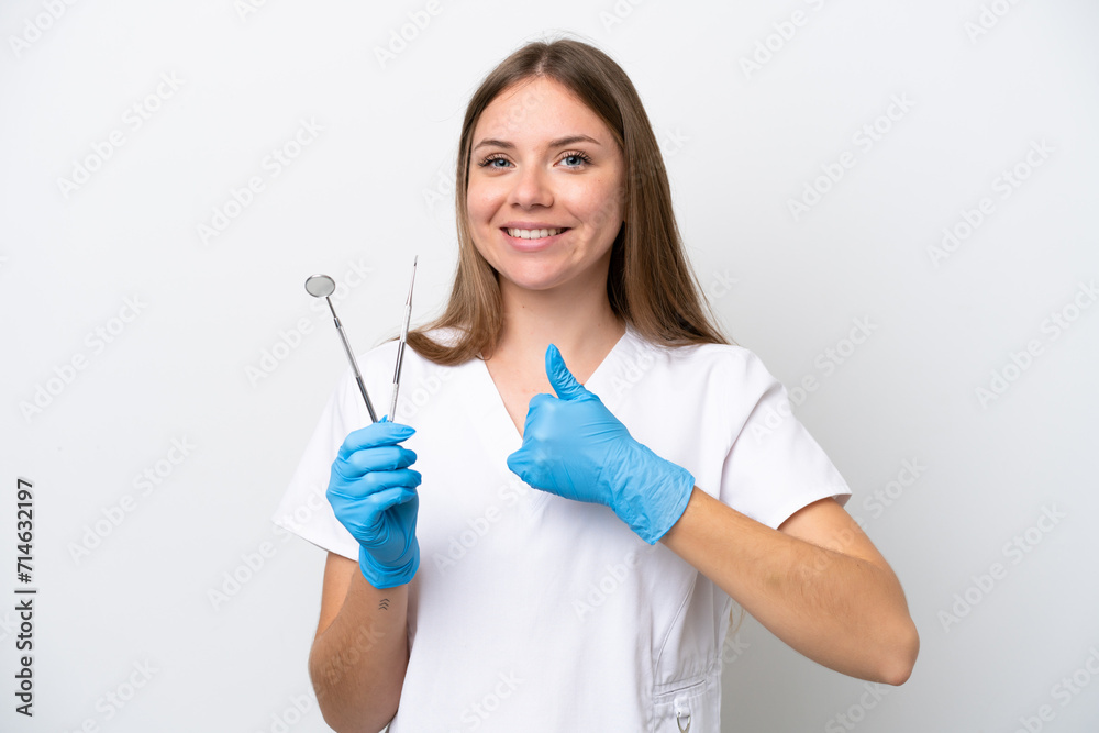 Dentist woman holding tools isolated on white background giving a thumbs up gesture Dentist woman holding tools isolated on white background giving a thumbs up gesture
