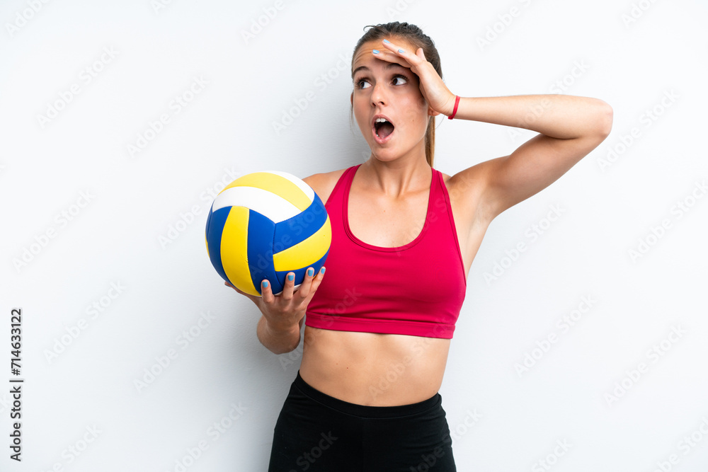 Young caucasian woman playing volleyball isolated on white background doing surprise gesture while looking to the side Young caucasian woman playing volleyball isolated on white background doing surprise gesture while looking to the side
