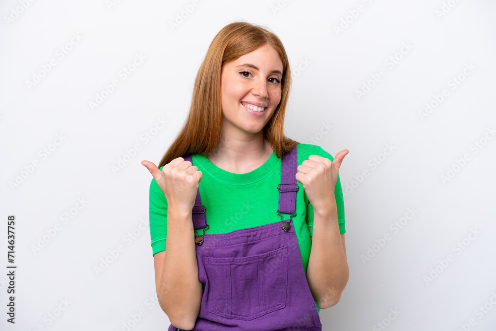 Young redhead woman isolated on white background with thumbs up gesture and smiling Young redhead woman isolated on white background with thumbs up gesture and smiling