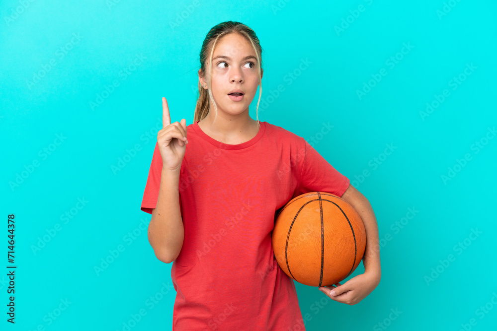 Little caucasian girl playing basketball isolated on blue background thinking an idea pointing the finger up Little caucasian girl playing basketball isolated on blue background thinking an idea pointing the finger up