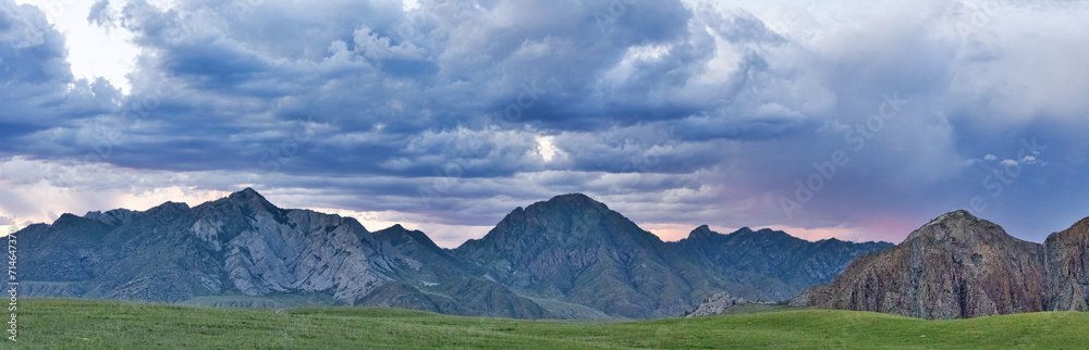 rocky mountains in Altai under lilac sunset clouds