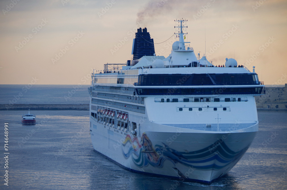 Modern family cruiseship or cruise ship liner Spirit arrival into Valletta port on Malta summer during Mediterranean cruising dream vacation with old town city skyline
