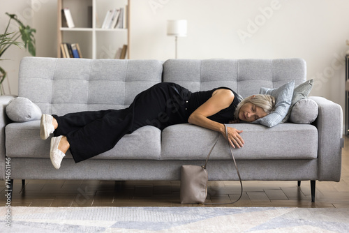 Tableau sur toile Full-length view tired mature woman felt asleep on sofa, arrive at home after party or hard-working day, flopped down on couch looks squeezed like lemon, need rest for restoring