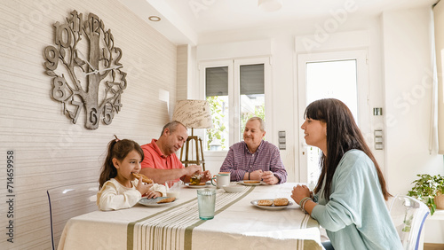 Happy gay couple eating breakfast with daughter and granddaughter