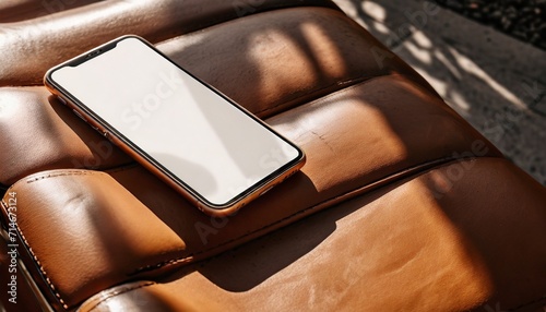 mobile phone with copy space screen on leather bench with aesthetic sunlight shadows photo