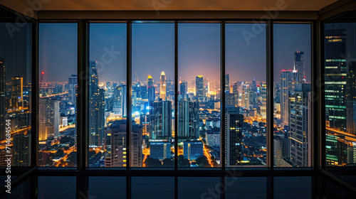 An empty room in a skyscraper and a view of the night city. Beautiful expensive property with a view. photo