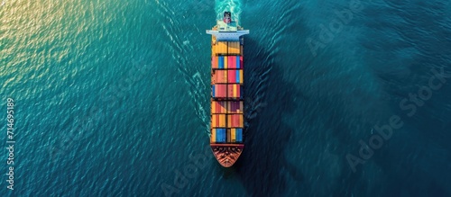 Container ship seen from above, moving on open ocean while transporting cargo. photo