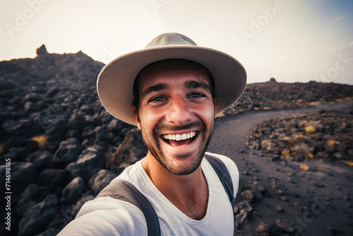 A confident and carefree man taking a selfie at a volcano crater during an adventurous journey.
