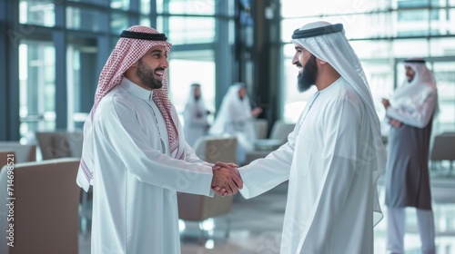 Obraz na płótnie Middle Eastern Business Partners Striking a Successful Deal at a Corporate Modern Meeting Room. Two Arab Men Shaking Hands, Managers in Traditional White Robes Celebrating and Clapping Hands w salonie