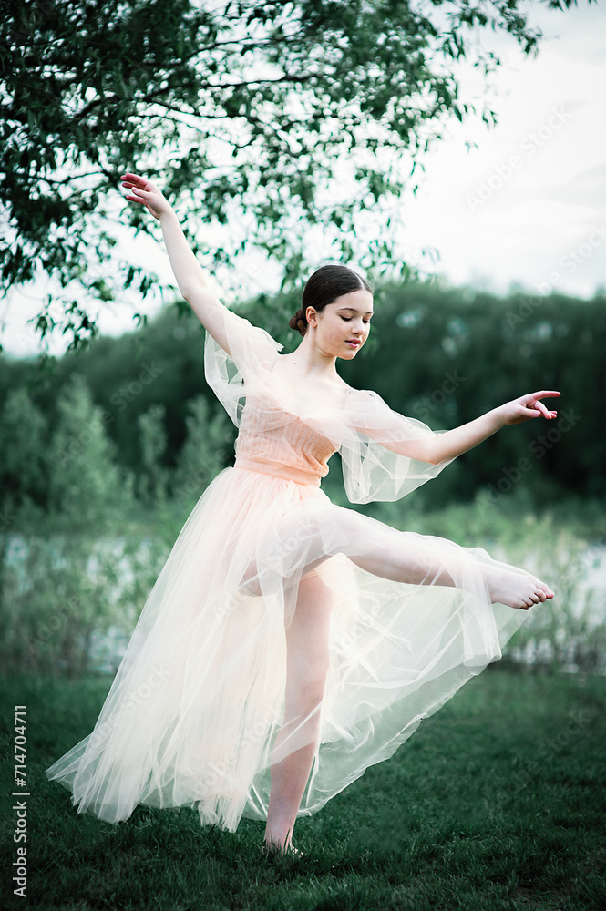 A young young dancer in an airy long beige dress dances among spring nature. A young young dancer in an airy long beige dress dances among spring nature.