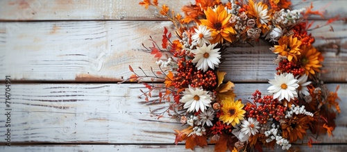 Autumn wreath with flowers on wooden background.
