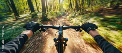Cyclist speeding through forest on trail for sport, fitness, and adventure in nature. photo