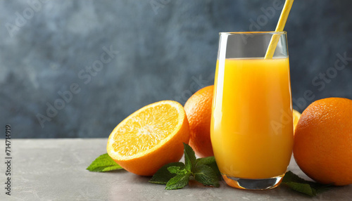 Delicious orange juice and fresh fruit on grey table, space for text