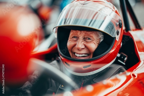 old woman inside a racing car, with helmet, the focus is her laughing, retirement concept. old age driving. extreme sport racing © Gasi